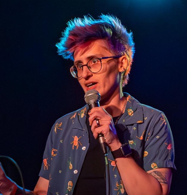 Dr Tai Josek with microphone on stage